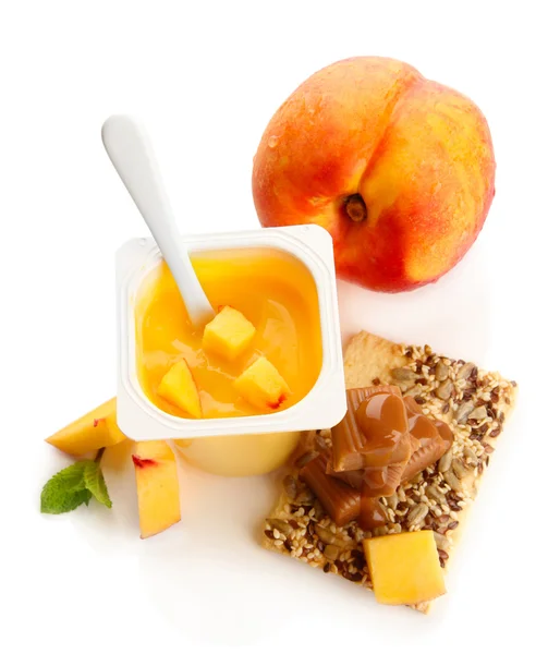 Chutné jogurt s kousky čerstvého ovoce, sušenky a cukroví karamely izolované na bílém — Stock fotografie