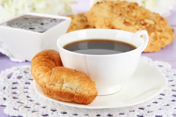 Croissant gustosi e una tazza di caffè in tavola primo piano — Foto Stock