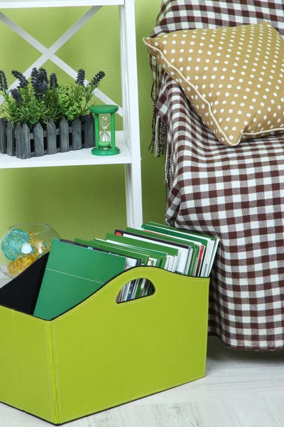 Revistas y carpetas en caja verde en el piso en la habitación — Foto de Stock