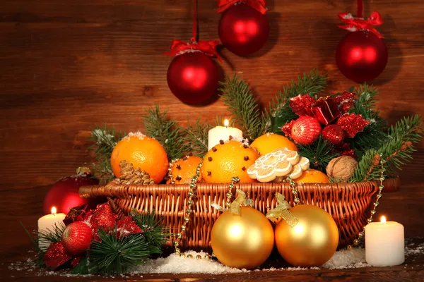 Kerstmis samenstelling in de mand met sinaasappels en fir tree, op houten achtergrond — Stockfoto