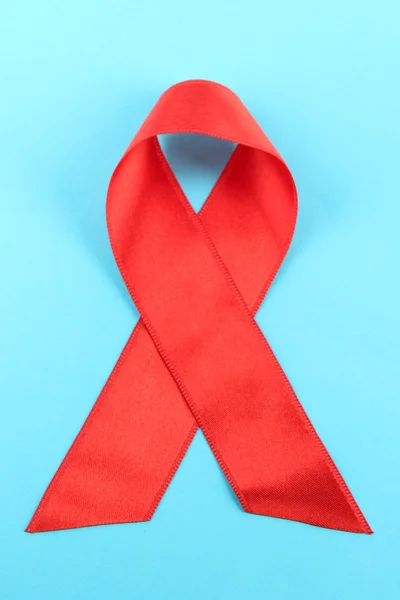 Kırmızı kurdele HIV, AIDS üzerinde mavi arka plan — Stok fotoğraf