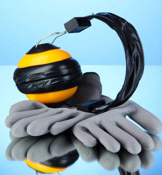 Beschermende handschoenen en koptelefoon op blauwe achtergrond — Stockfoto