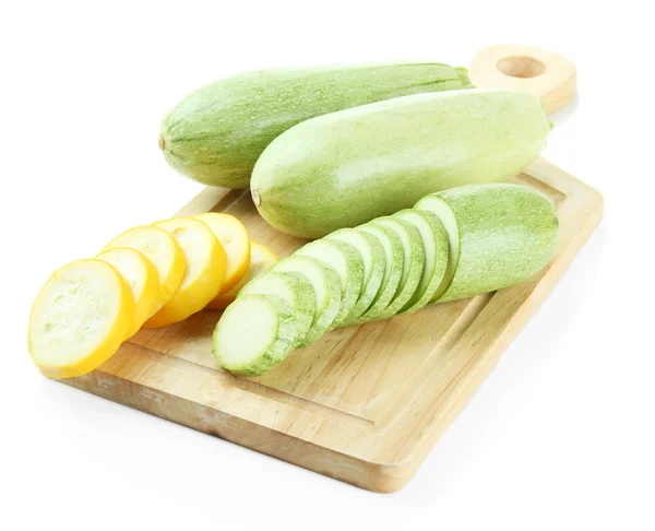 Sliced and whole raw zucchini on wooden cutting board, isolated on white — Stock Photo, Image