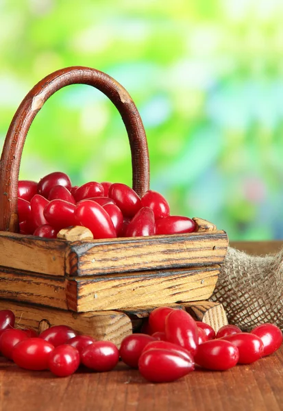 Frische Kornelkirschen im Korb auf Holztisch — Stockfoto