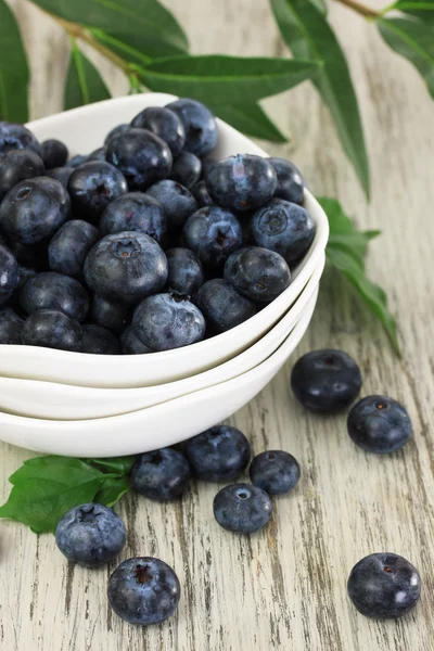 Blueberries in bowls on wooden table — Stock Photo, Image