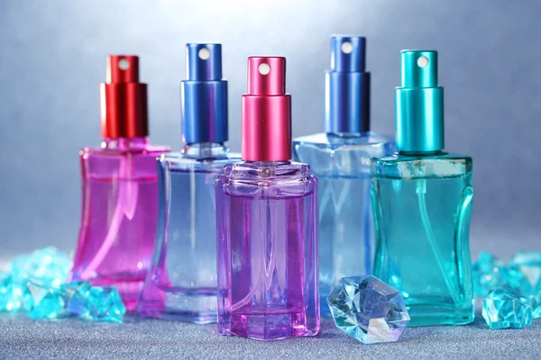 Perfumy kobiety w pięknych butelkach na jasnym tle — Zdjęcie stockowe