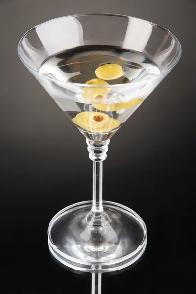 Gri zemin üzerine yeşil zeytinli martini — Stok fotoğraf