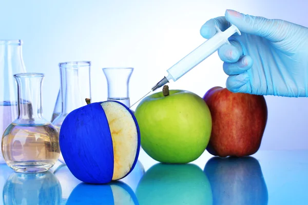 Injektion in Apfel auf blauem Hintergrund — Stockfoto