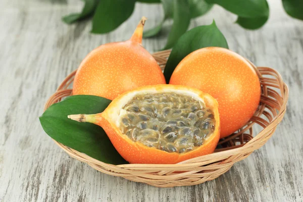 Passion fruits in wicker basket on table close-up — Stock Photo, Image