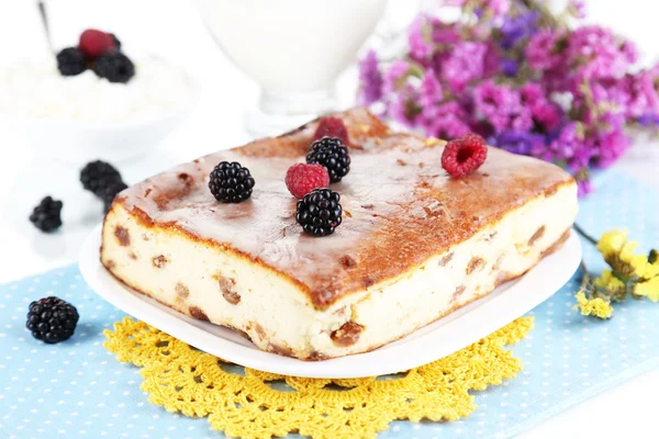 Cheese casserole with raisins on plate on napkin isolated on white — Stock Photo, Image