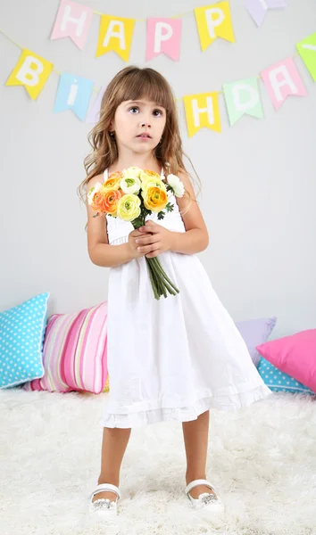 Kislány és virágok a szobában, a szürke háttér — Stock Fotó