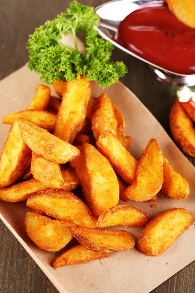 Home potatoes on tracing paper on wooden table — Stock Photo, Image