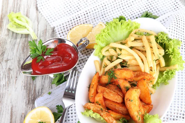 French fries and home potatoes on plate on board on napkin on wooden table — Stock Photo, Image