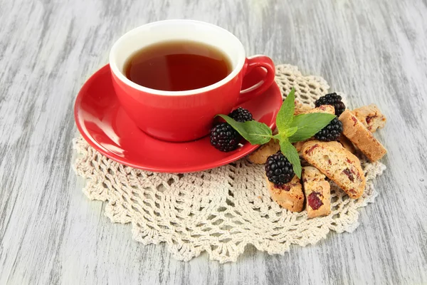 Чашка чая с печеньем и ежевикой на столе крупным планом — стоковое фото