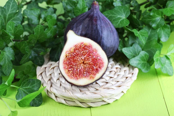 Ripe figs in leaves on wooden table close-up — Stock Photo, Image