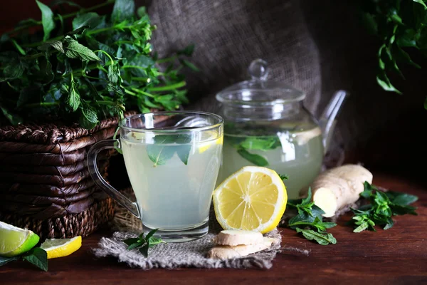 Vattenkokare och kopp te med ingefära på träbord på ljus bakgrund — Stockfoto