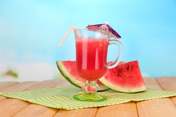 Glass of fresh watermelon juice, on wooden table, on bright background — Stock Photo, Image