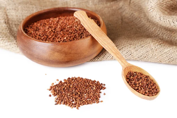 Buckwheat groats in bowl and wooden spoon isolated on white — Stock Photo, Image