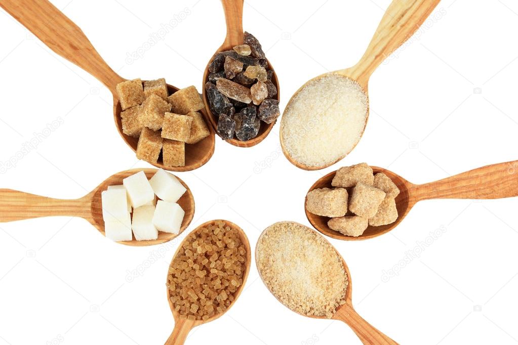 Different types of sugar in spoons isolated on white
