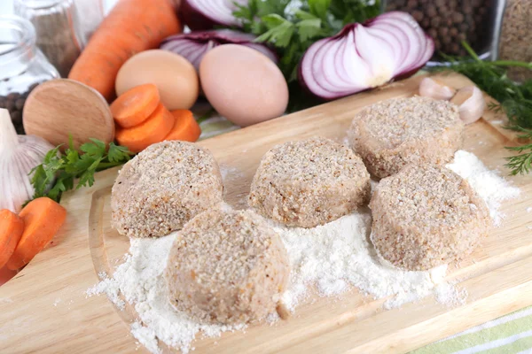 Meat patties on board on napkin — Stock Photo, Image