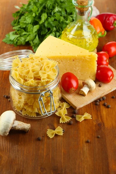 Pasta with oil, cheese and vegetables on wooden table close-up — Stock Photo, Image