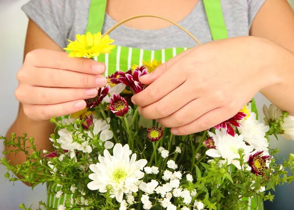 Fiorista rende mazzo di fiori in cesto di vimini — Foto Stock