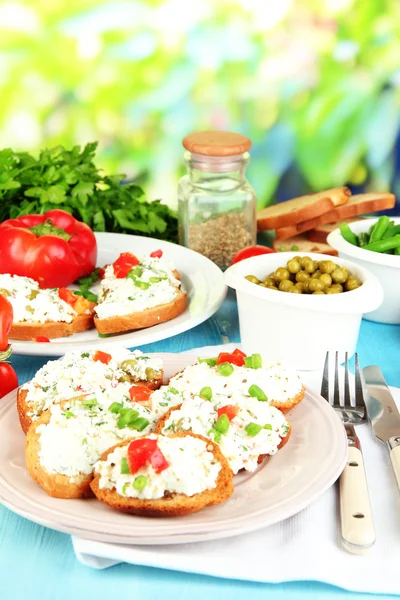 Sandwiches with cottage cheese and greens on plate on wooden table on natural background — Stock Photo, Image