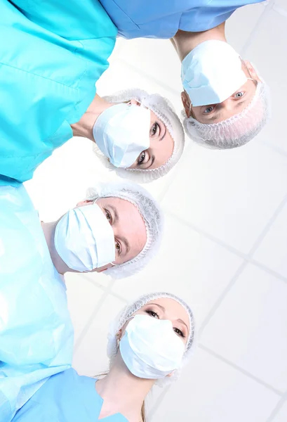 Vista de baixo de cirurgiões em desgaste de trabalho de proteção durante a operação — Fotografia de Stock