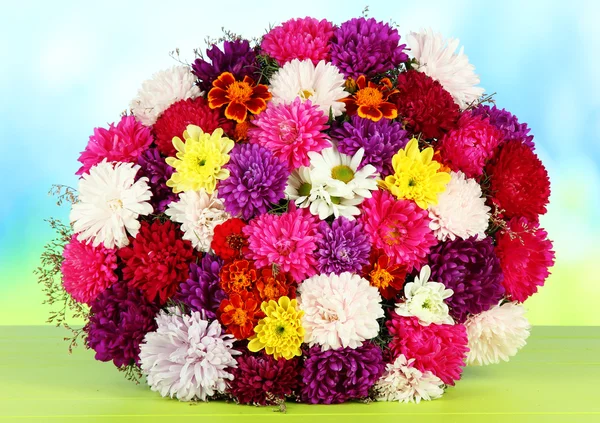 Beautiful bouquet of chrysanthemums on table on bright background — Stock Photo, Image