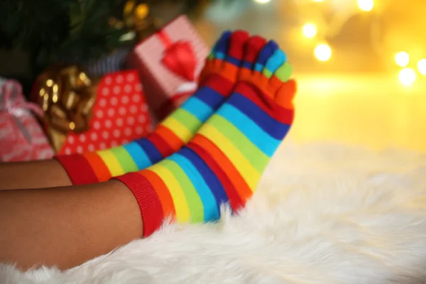Legs in socks near Christmas tree on carped — Stock Photo, Image