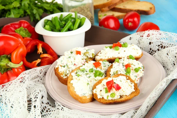 Sandwiches with cottage cheese and greens on plate on wooden table close-up — Stock Photo, Image
