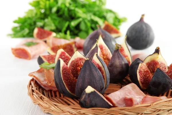 Smakelijke vijgen met ham op witte houten tafel — Stockfoto