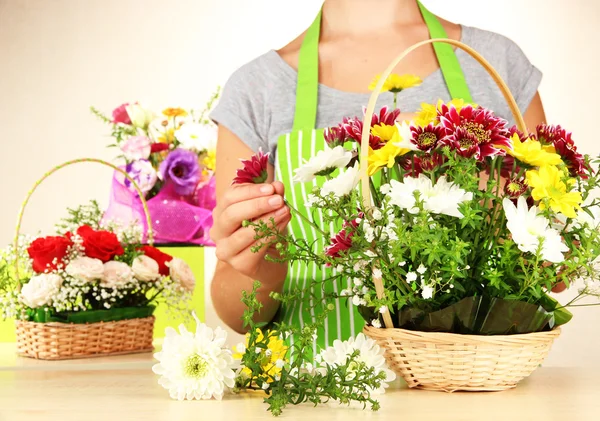 Fiorista rende mazzo di fiori in cesto di vimini — Foto Stock