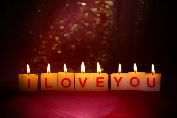 Candles with printed sign I LOVE YOU,on blur lights background — Stock Photo, Image