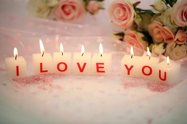 Kerzen mit bedrucktem Zeichen ich liebe dich, auf farbigem Stoffhintergrund — Stockfoto