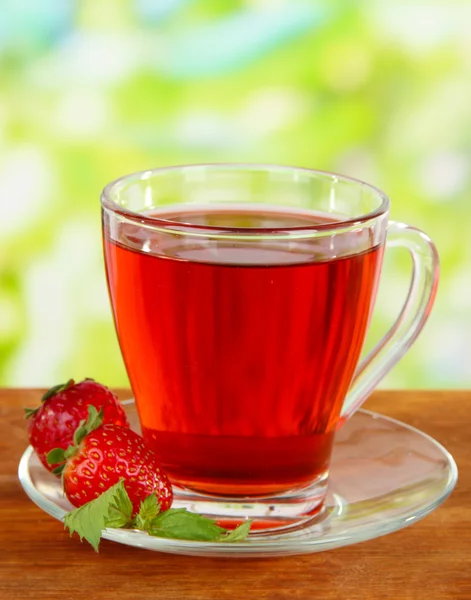 Delicious strawberry tea on table on bright background — Stock Photo, Image