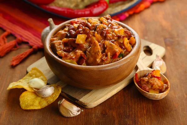 Carne de maíz con chile - comida tradicional mexicana, en tazón de madera, en servilleta, sobre fondo de madera — Foto de Stock