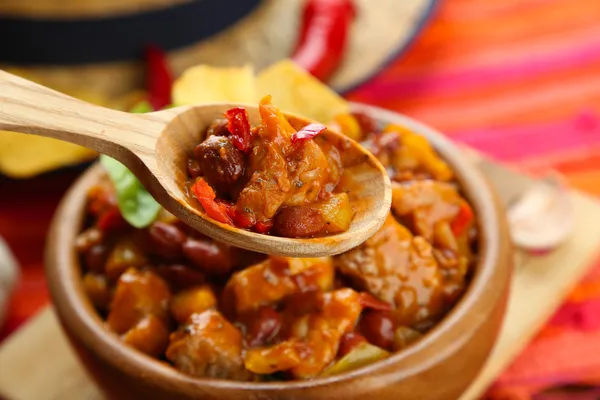 Carne de maíz con chile - comida tradicional mexicana, en tazón de madera, en servilleta, sobre fondo de madera —  Fotos de Stock