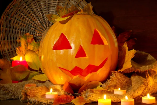 Zucca di Halloween e foglie autunnali, su sfondo di legno — Foto Stock