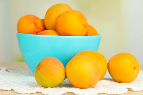 Свежий натуральный абрикос в миске на столе на кухне — стоковое фото
