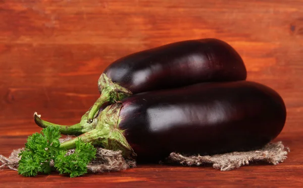 Verse aubergines op tafel op houten achtergrond — Stockfoto