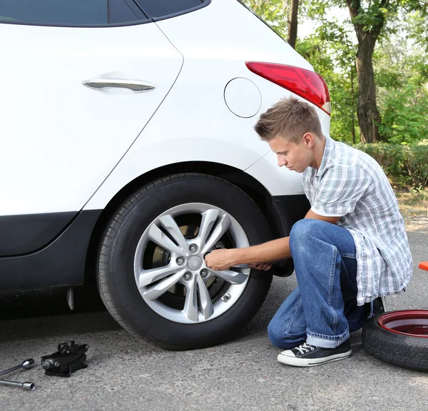 Man driver having trouble at road changing wheel — Stock Photo, Image