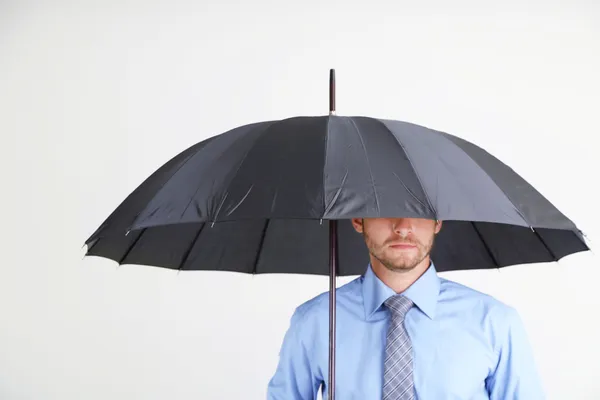 Empresario con paraguas. sobre fondo gris —  Fotos de Stock