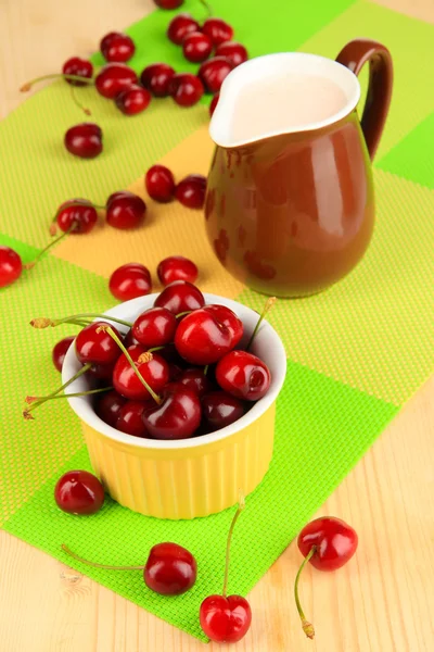 Bayas rojas maduras de cereza en un tazón sobre una mesa de madera — Foto de Stock