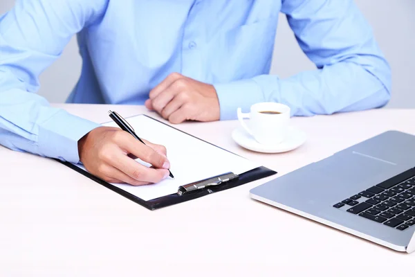 Empresario escribiendo sobre documento en primer plano de la oficina — Foto de Stock