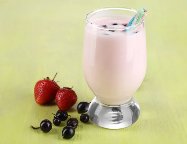 Heerlijke milkshake met blackberry en aardbeien op houten tafel close-up — Stockfoto