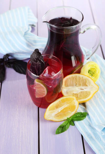 Rode basilicum limonade in kruik en glas, op houten achtergrond — Stockfoto