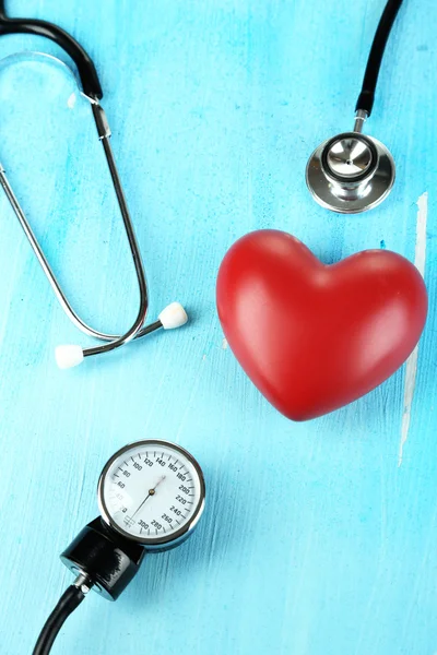 Tonometro, stetoscopio e cuore sul tavolo di legno primo piano — Foto Stock