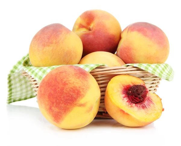 Reife süße Pfirsiche im Weidenkorb, isoliert auf weiß — Stockfoto
