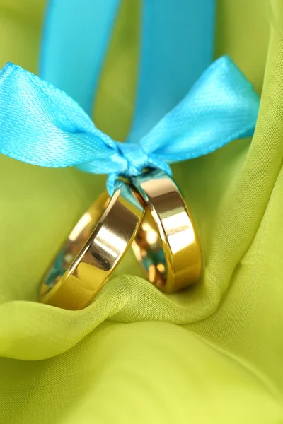 Anillos de boda atados con cinta en tela brillante — Foto de Stock